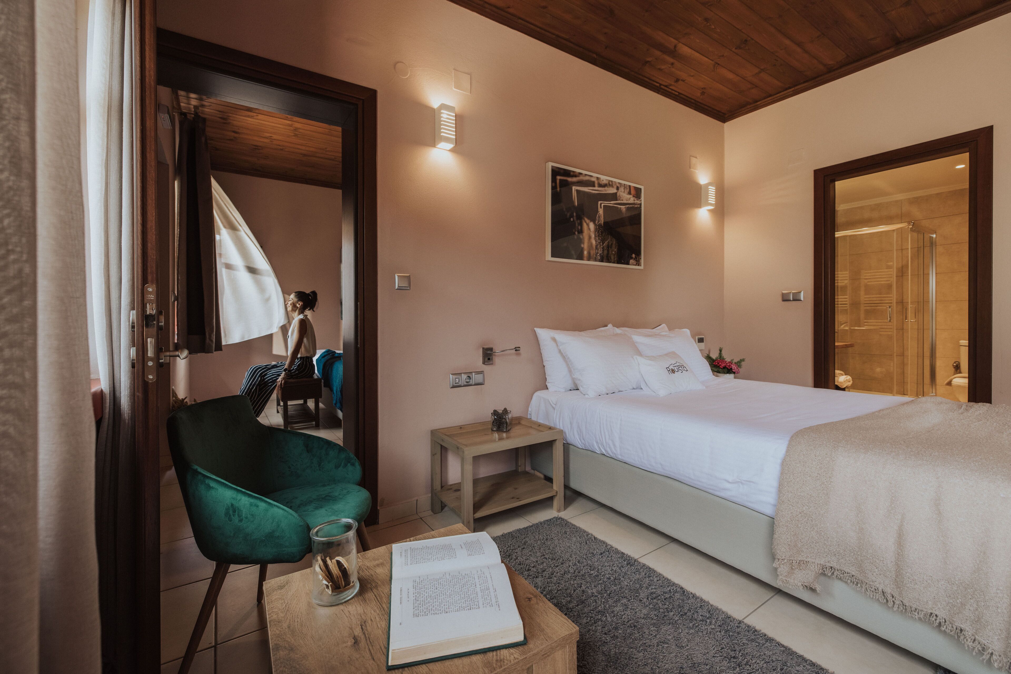 A bedroom with a bed, a chair, a bedside table, and a nightstand.