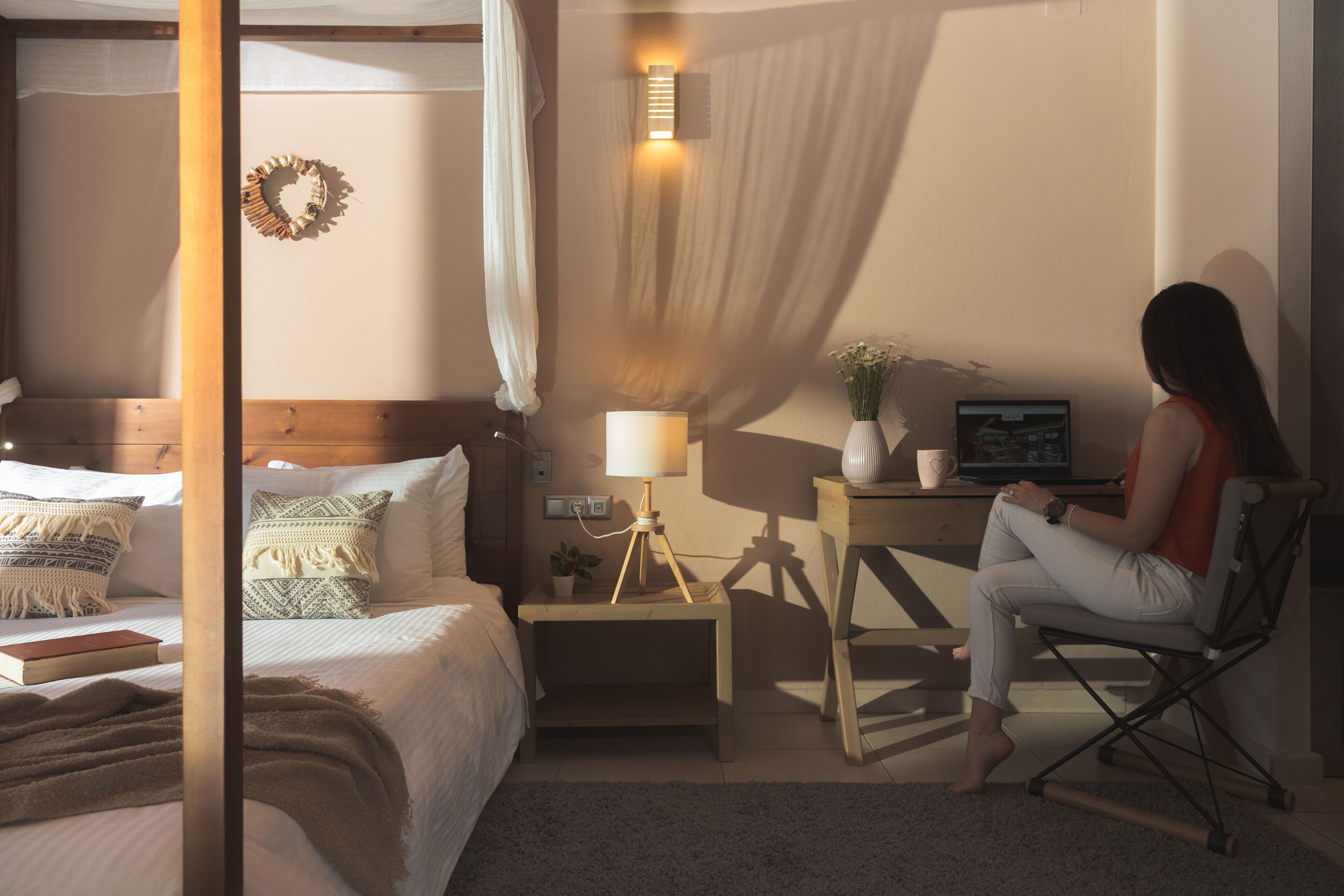 Un dormitorio con cama, mesita de noche, lámpara y un escritorio con silla.