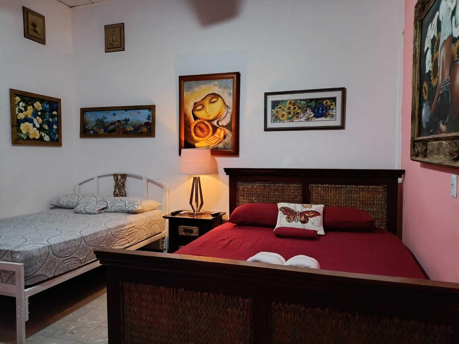 Ein Schlafzimmer mit einem Bett, einem Einzelbett und einem Nachttisch mit Lampe.