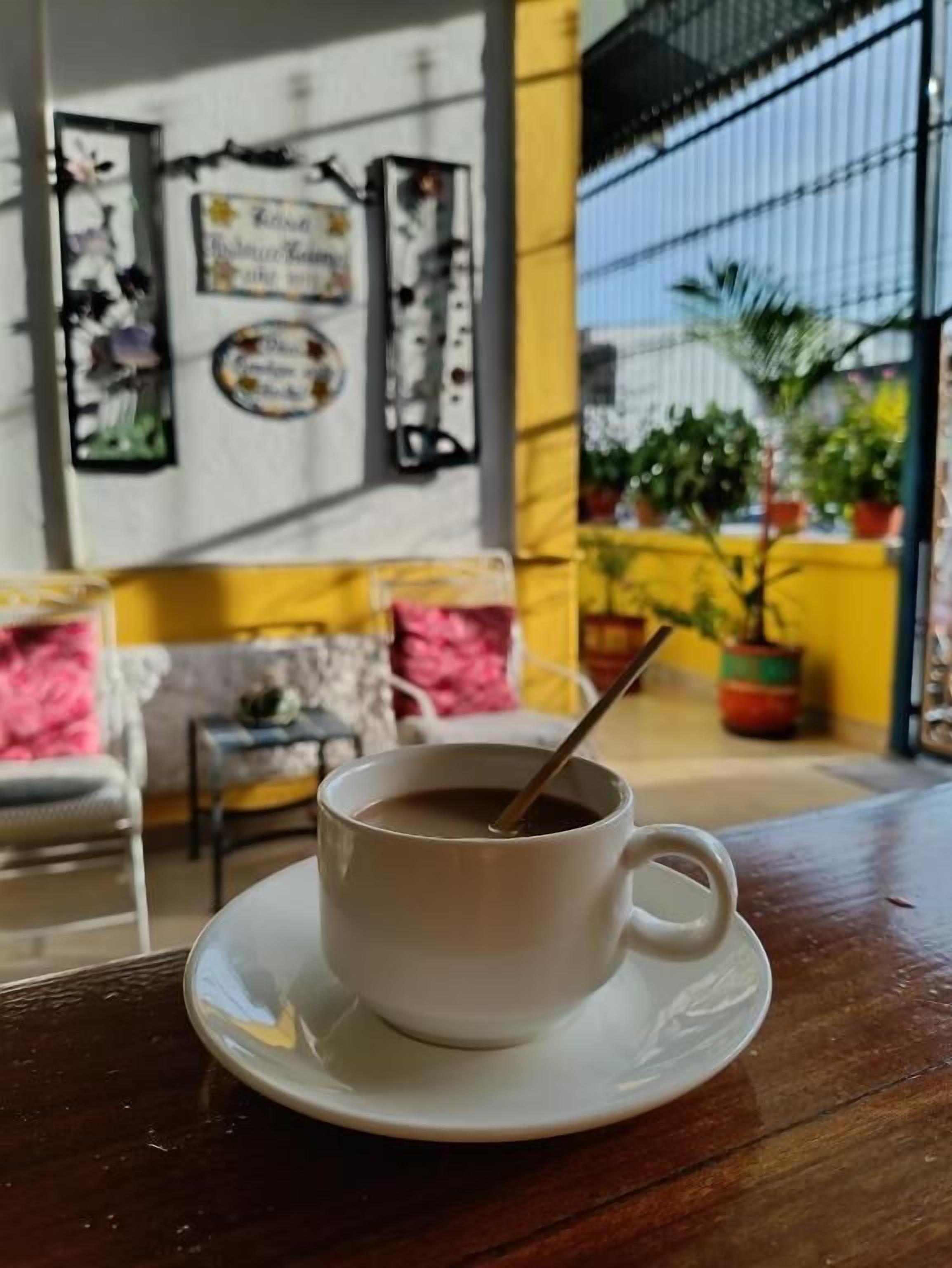 A cup of coffee on a saucer with a spoon, on a wooden table.
