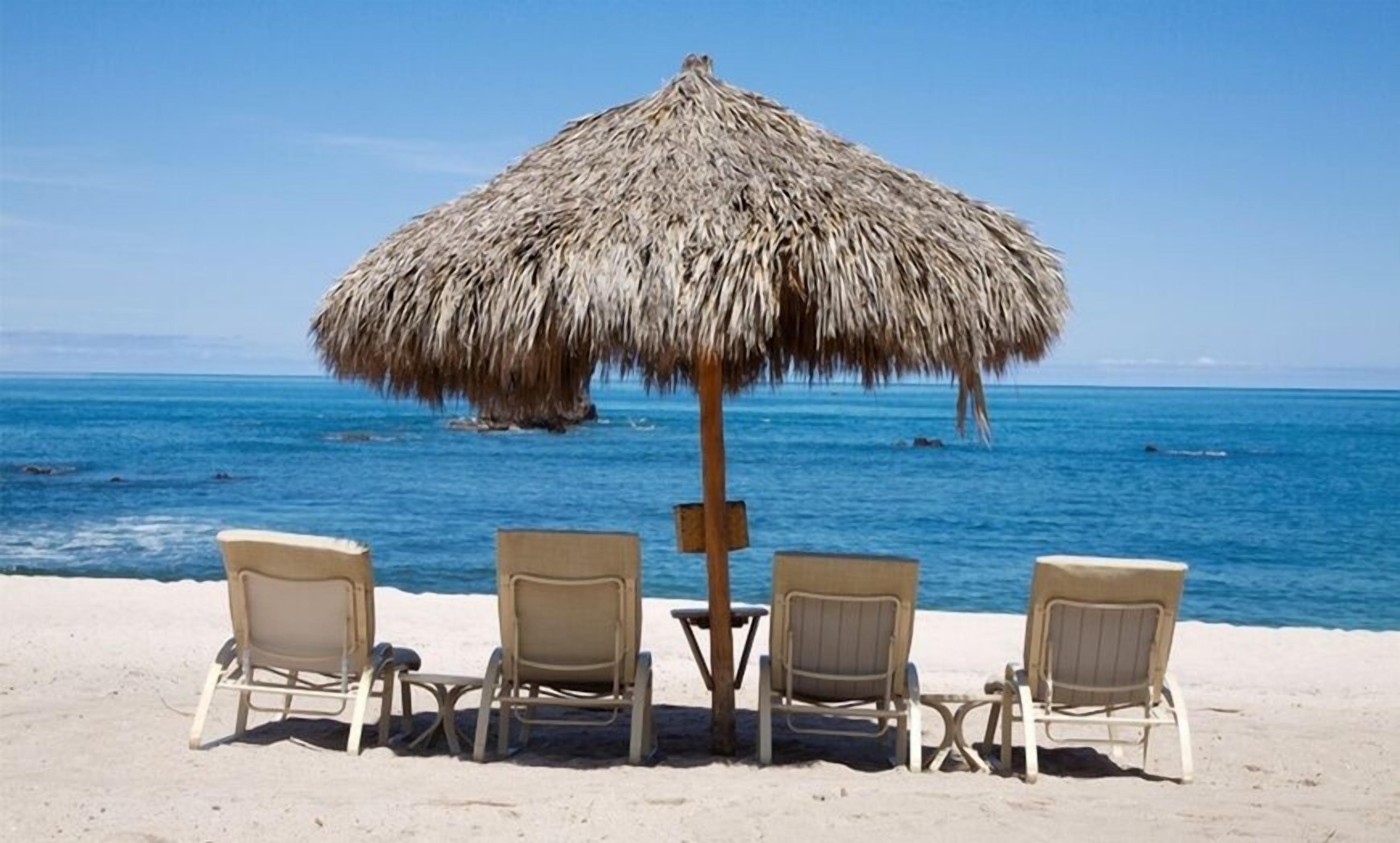 A beach with three lounge chairs and a thatched umbrella.