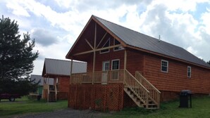 Une cabane en bois dotée d’une terrasse en bois et d’un escalier menant à un balcon.