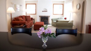 Ein Esstisch mit einer Blumenvase in der Mitte.