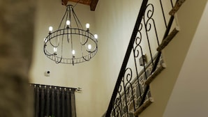 A chandelier with multiple bulbs hanging from a circular metal frame. - Casa Gaçe Hotel (Qendër Bulgarec)