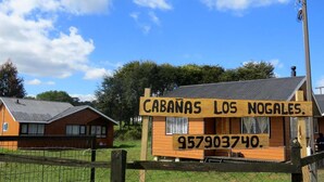 Puinen kyltti, jossa lukee teksti ”CABANAS LOS NOGALES” ja puhelinnumero ”957903740”.