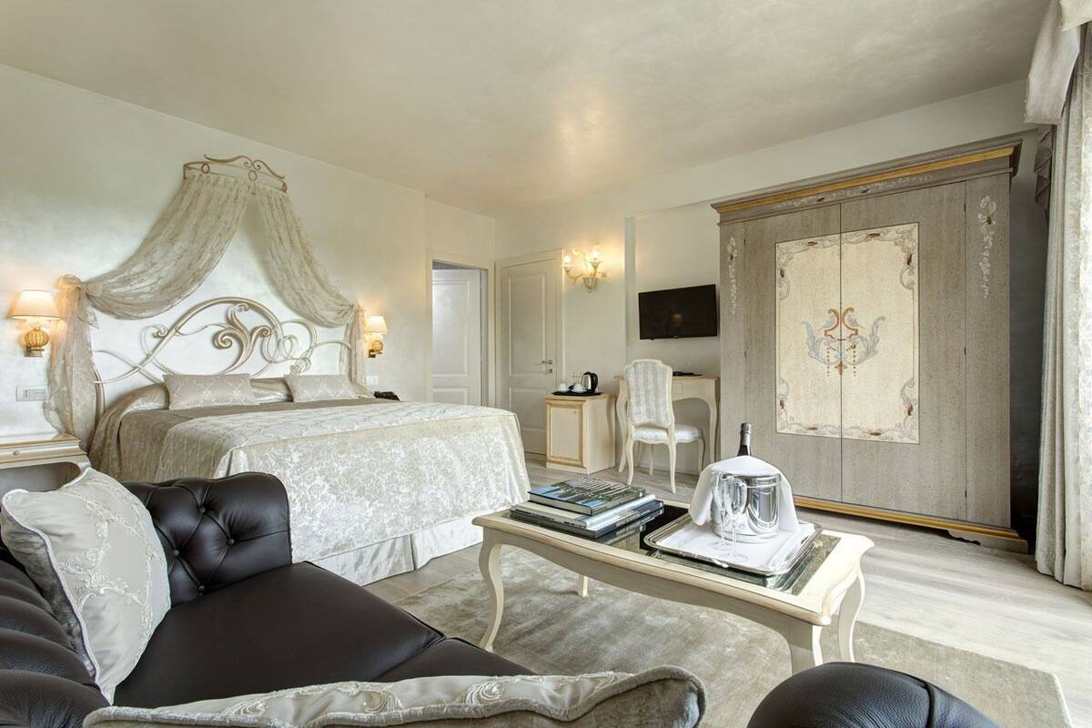 Ein Hotelzimmer mit Bett, Sitzecke mit Couchtisch, Schreibtisch und Fernseher.