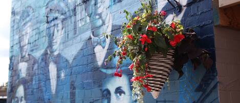 A mural with a hanging flower basket.