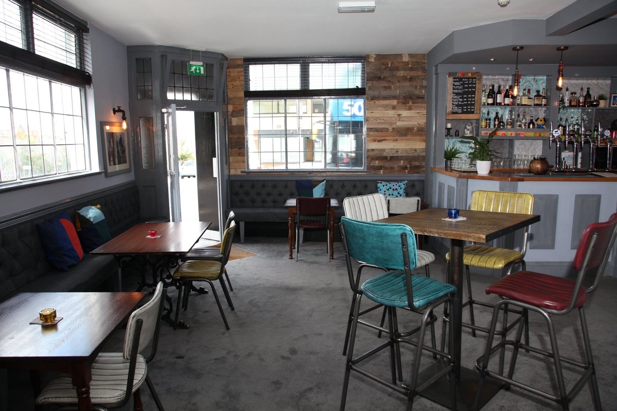 A restaurant with a bar area, wooden walls, and a seating arrangement including tables and chairs.