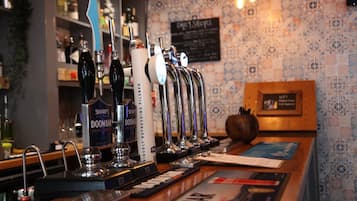 Un bar con múltiples grifos, un panel de menú y una barra de madera.