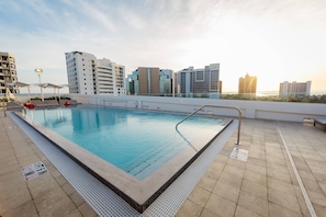 A rooftop pool with clear blue water, surrounded by modern buildings and a clear sky. - Art Ovation Hotel, Autograph Collection (Sarasota)