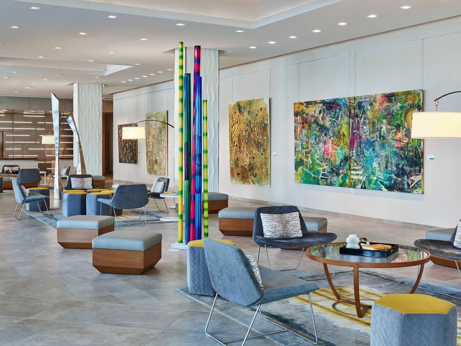A modern lobby with seating areas, abstract art, and a reception desk.