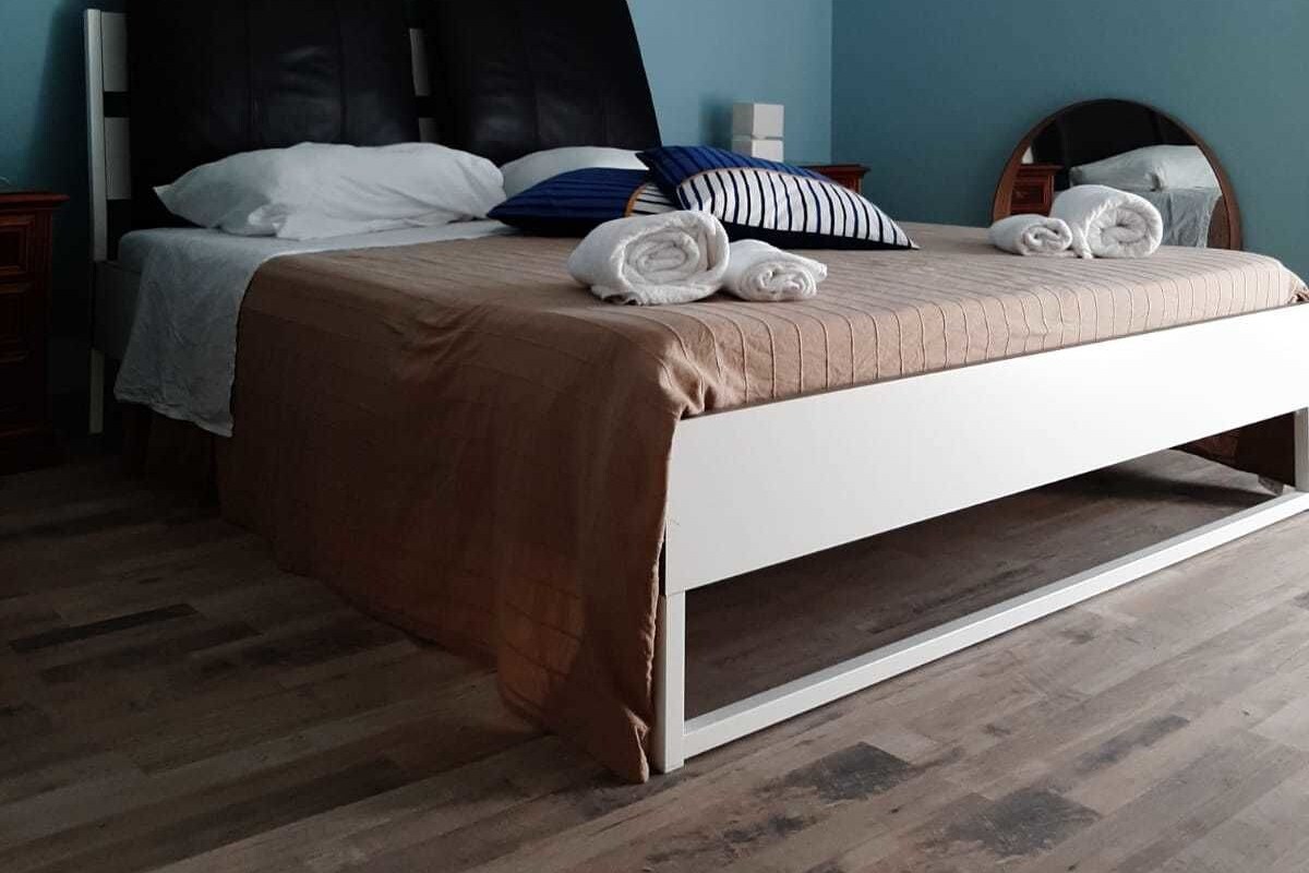 Quarto com cama, dois aparelhos de ar condicionado fixados na parede e duas quadros emoldurados.