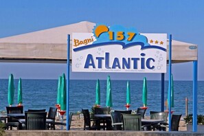 A beachside restaurant named 'Bagni 157 Atlantic' with outdoor seating and umbrellas. - Hotel Atlantic (Senigallia)
