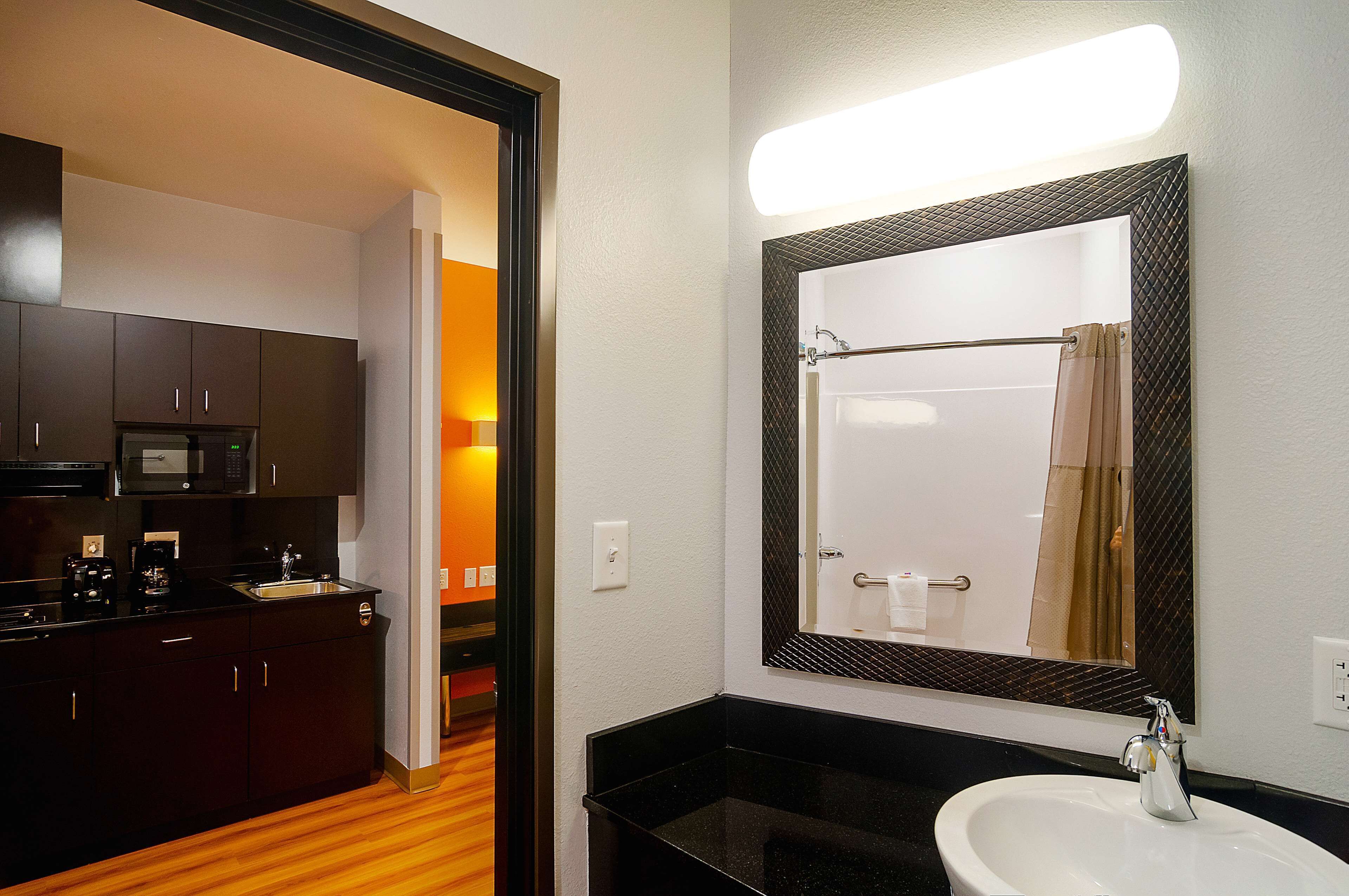 Une salle de bain d’hôtel avec un grand miroir, un lavabo et une douche.