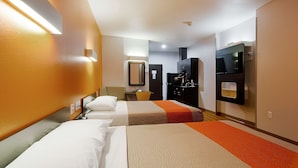 Une chambre d’hôtel avec deux lits, un bureau, une chaise, une télévision et un mini-bar.