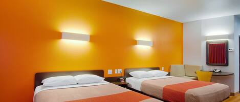 Ein Hotelzimmer mit zwei Betten, einem Schreibtisch und einem Stuhl.