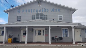 A two-story building with a covered front porch and a sign reading "Country Inn". - Countryside Inn (Princeton)