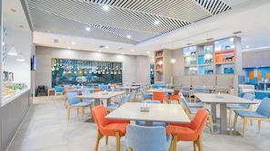 A modern dining area with multiple tables and chairs, a bar area with a large window, and decorative star lights. - Holiday Inn Express Chifeng Hongshan by IHG (Chifeng)