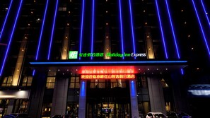 A hotel entrance with illuminated signage and vertical light strips. - Holiday Inn Express Chifeng Hongshan by IHG (Chifeng)