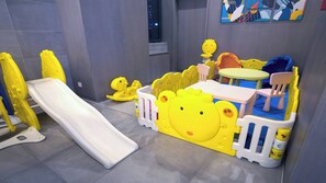 A children's play area with a slide, playpen, and a table with chairs. - Holiday Inn Express Chifeng Hongshan by IHG (Chifeng)