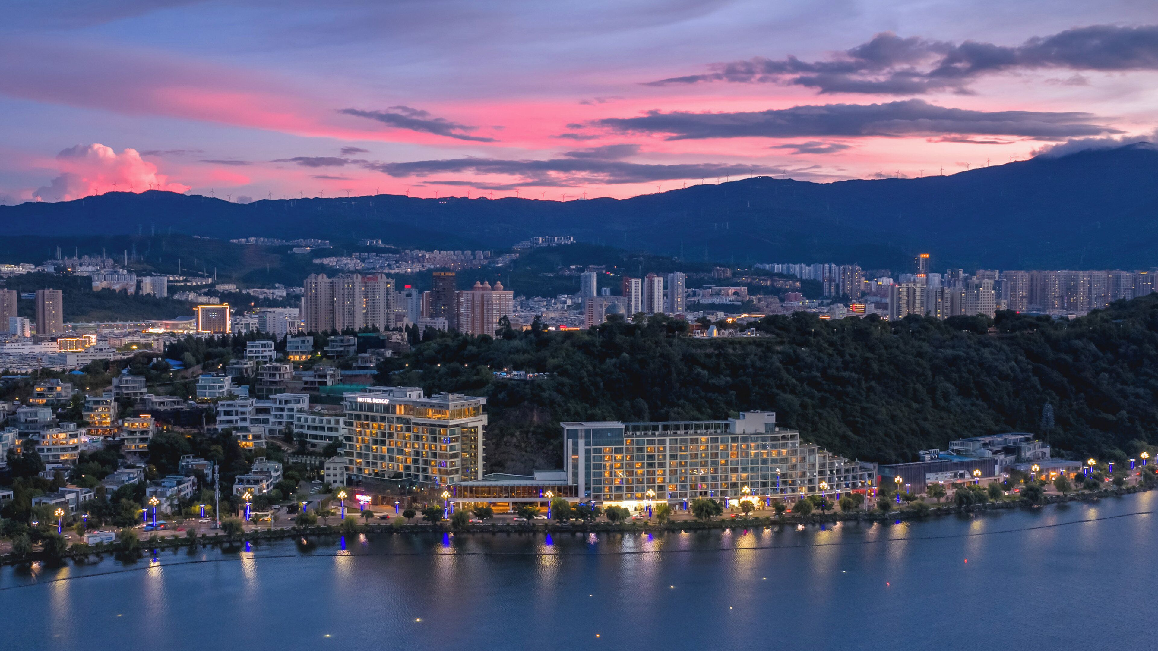 A cityscape with a hotel, high-rise buildings, and a river.