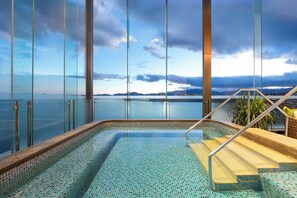 A pool with a view of the sea and mountains, surrounded by glass walls. - Hotel Indigo Dali Erhai by IHG (Dali)
