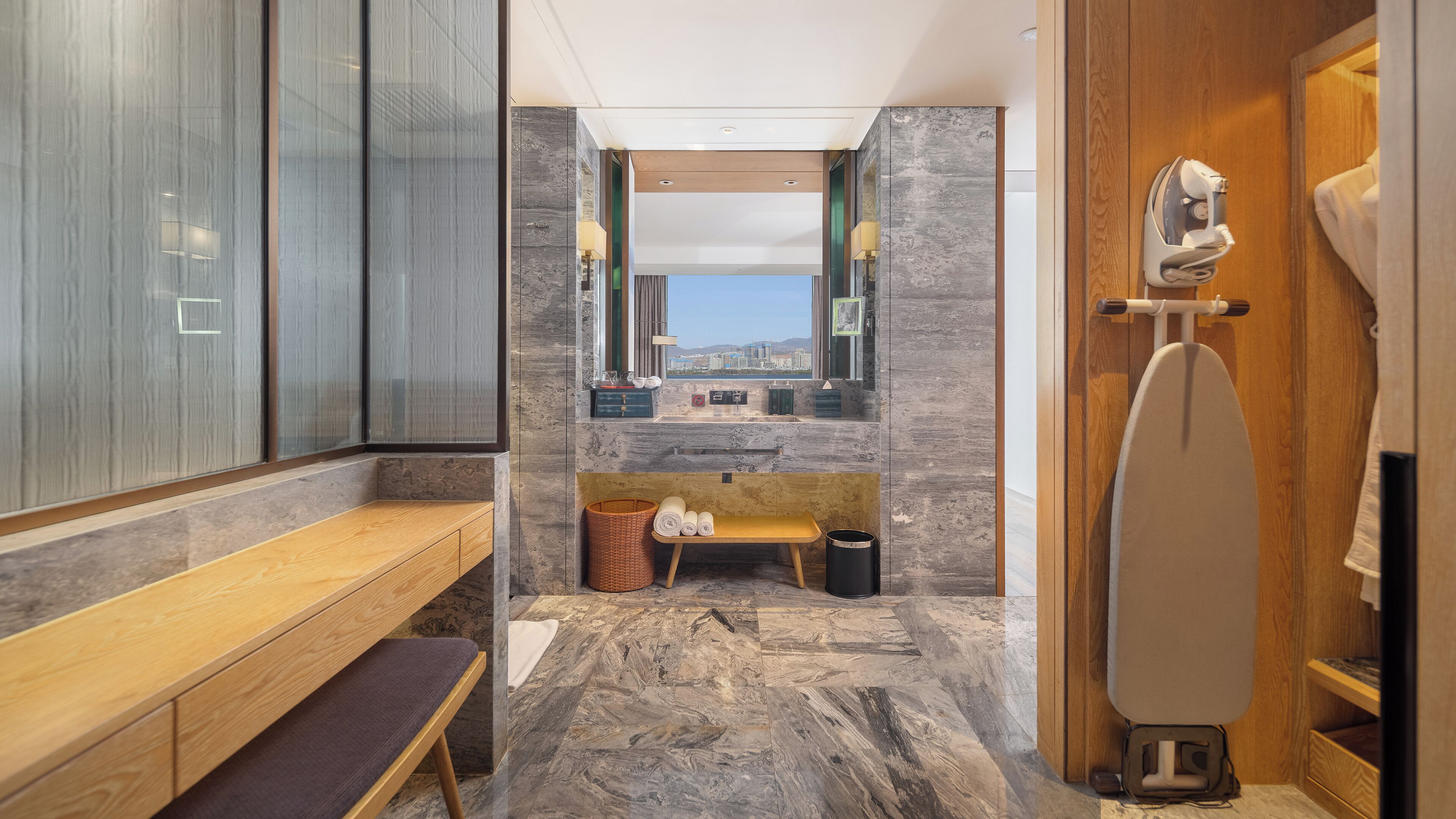 Une salle de bain moderne avec un banc en bois, un lavabo avec un miroir et des toilettes.