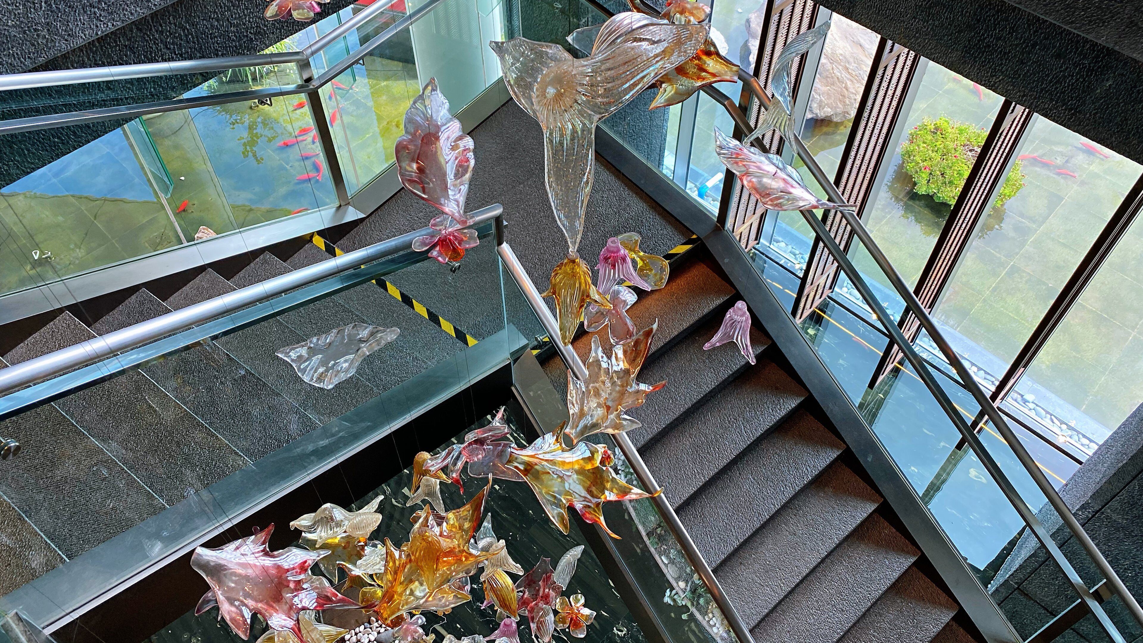 A glass staircase with a railing, surrounded by decorative glass elements.