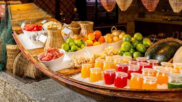 A buffet table with various fruits, vegetables, and beverages.