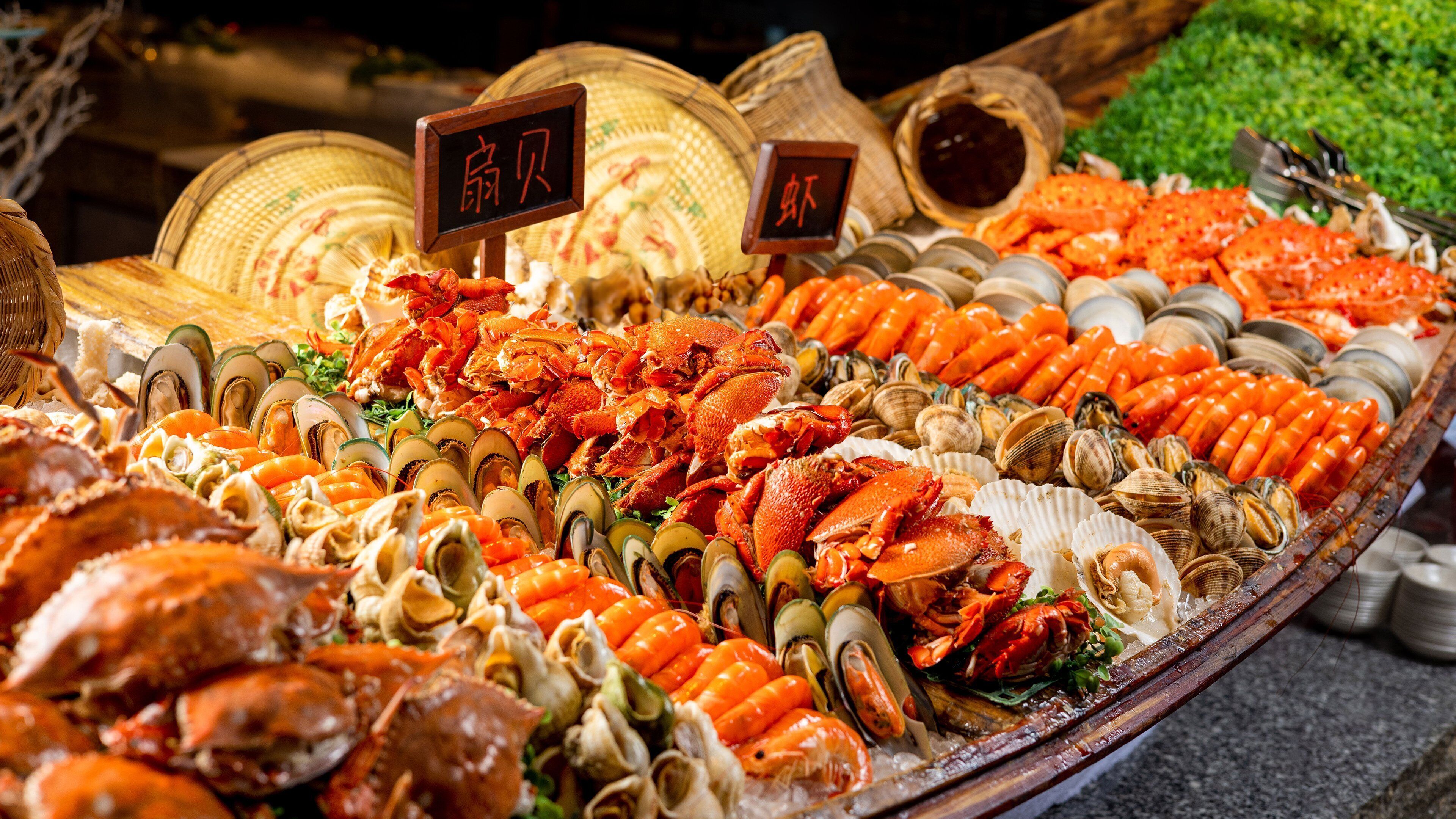 Exhibición de mariscos con diversos tipos de crustáceos y pescados, incluyendo cangrejos, almejas y camarones, dispuestos sobre hielo.