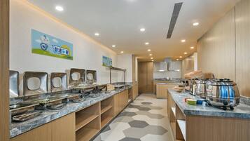 Una cocina moderna con un montaje tipo bufé, que incluye varias estaciones de servicio y una variedad de recipientes para alimentos.