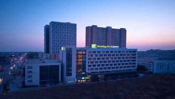 A multi-story hotel with a Holiday Inn Express sign, surrounded by other buildings and a busy street.