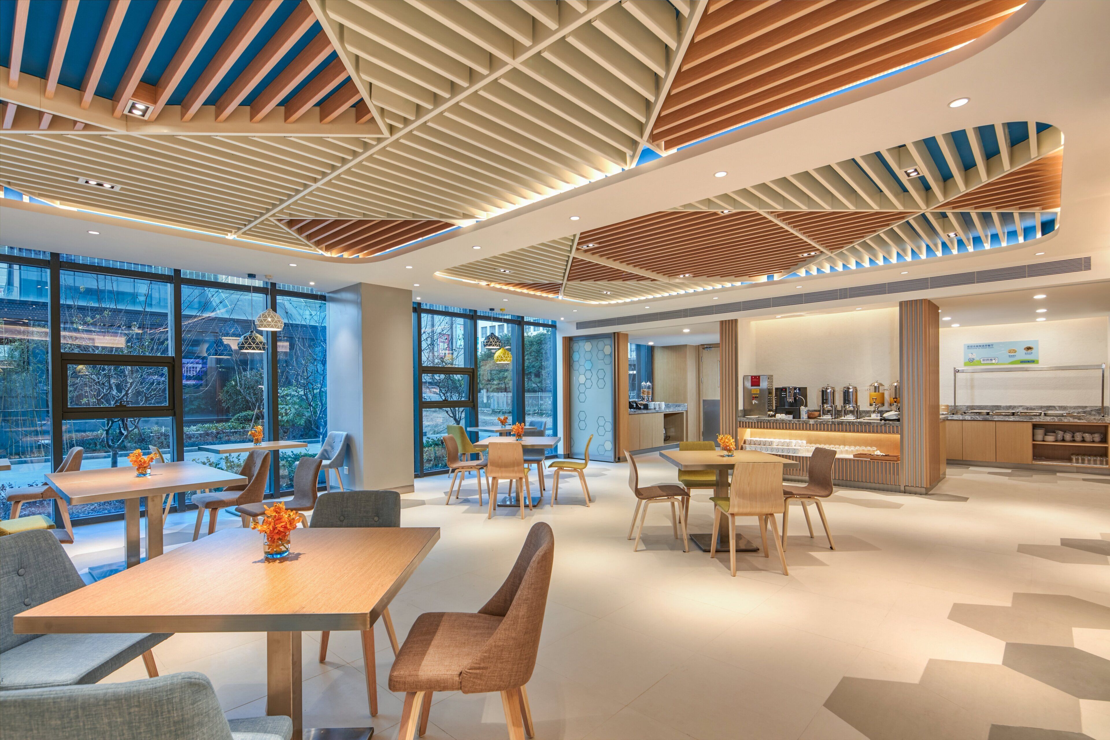Un interior moderno con comedor, cocina y ventanas amplias.