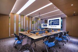 A conference room with a long table, chairs, a projector screen, and a presentation about Holiday Inn Express. - Holiday Inn Express Nantong Textile City by IHG (Nantong)