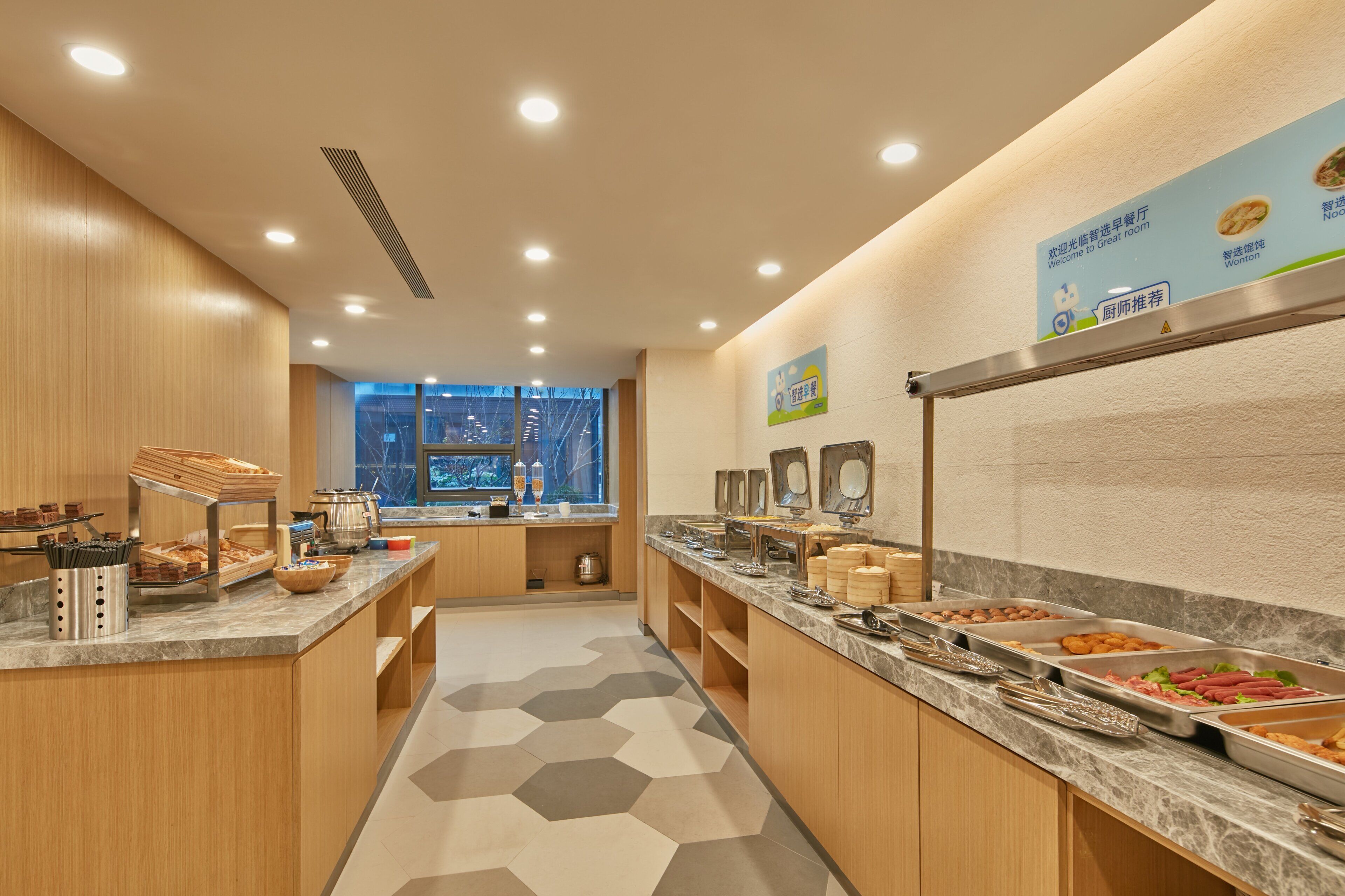 A breakfast buffet area with various food options, a window view, and a sign indicating a special room.