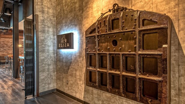 A wall with a metal panel and a sign that reads "ETIZA".