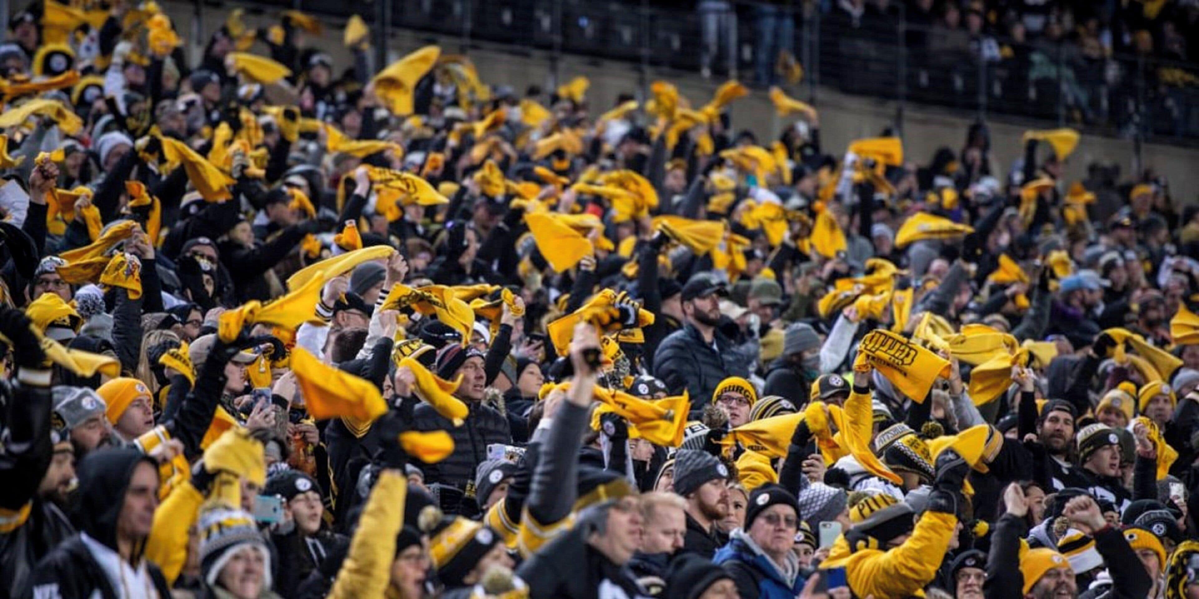 A crowded indoor space with numerous people, some wearing yellow and black attire.