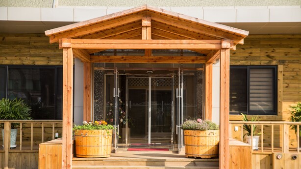 A wooden entrance with a glass door and steps leading up to it. - Daebudo Hotel Marina (Ansan)