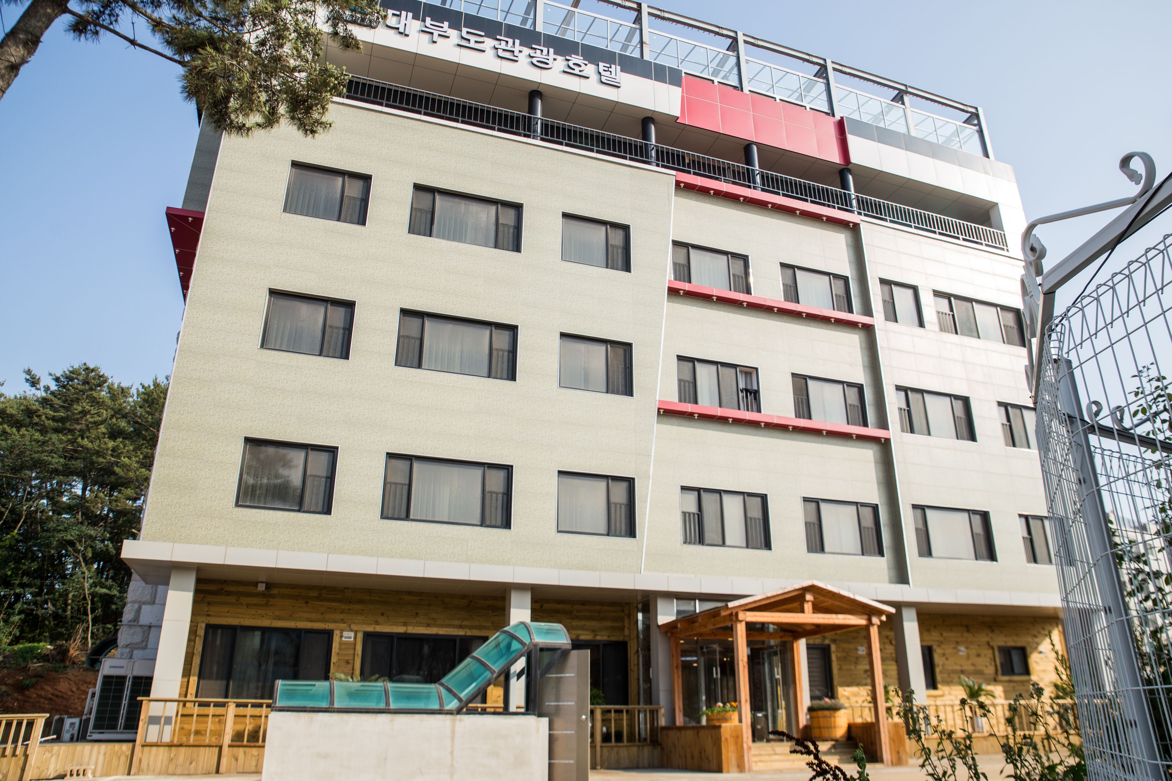 A multi-story hotel with a modern design, featuring a covered entrance and a slide for children.