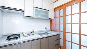 Una cocina moderna con un lavamanos de acero inoxidable, un microondas y una estufa a gas.