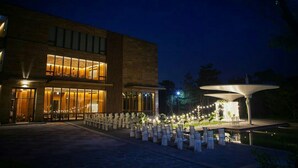 A modern building with large windows and a well-lit entrance. - Hotel Maestro (Anseong)