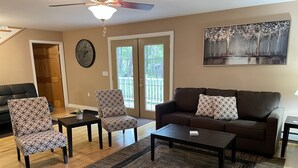 A living room with a brown sofa, patterned chairs, a coffee table, and a painting on the wall. - A Little Piece of Relaxation (Millport)