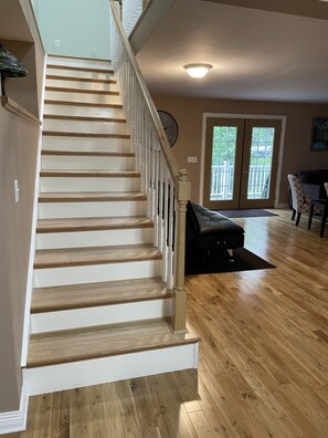 A staircase with wooden steps and white railings leading to a landing.