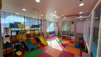 A play area with colorful mats, play structures, and a slide.