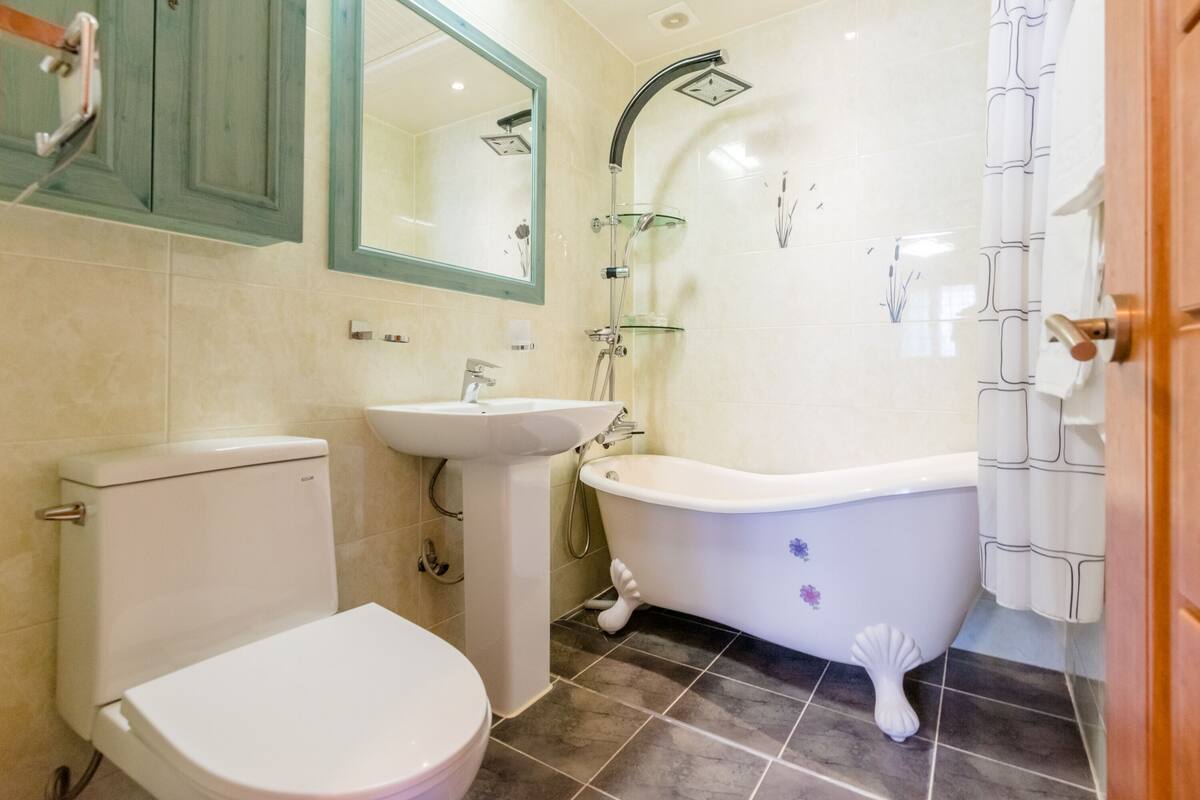 A bathroom with a toilet, sink, and bathtub.