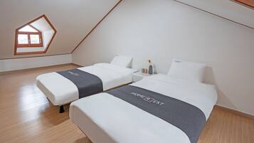 Un dormitorio moderno con dos camas, un tragaluz y suelo de madera.