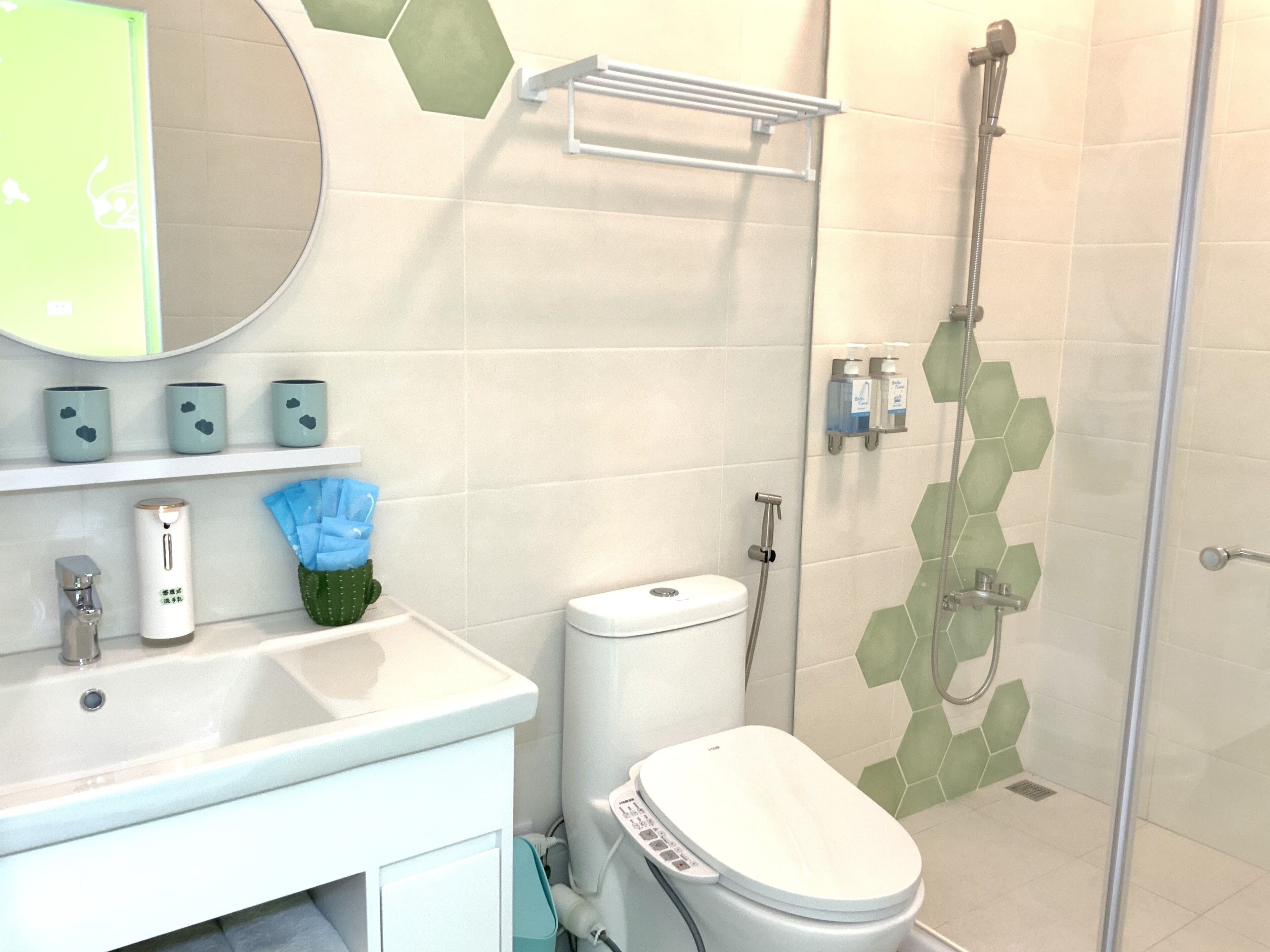 A modern bathroom with a toilet, sink, and shower.