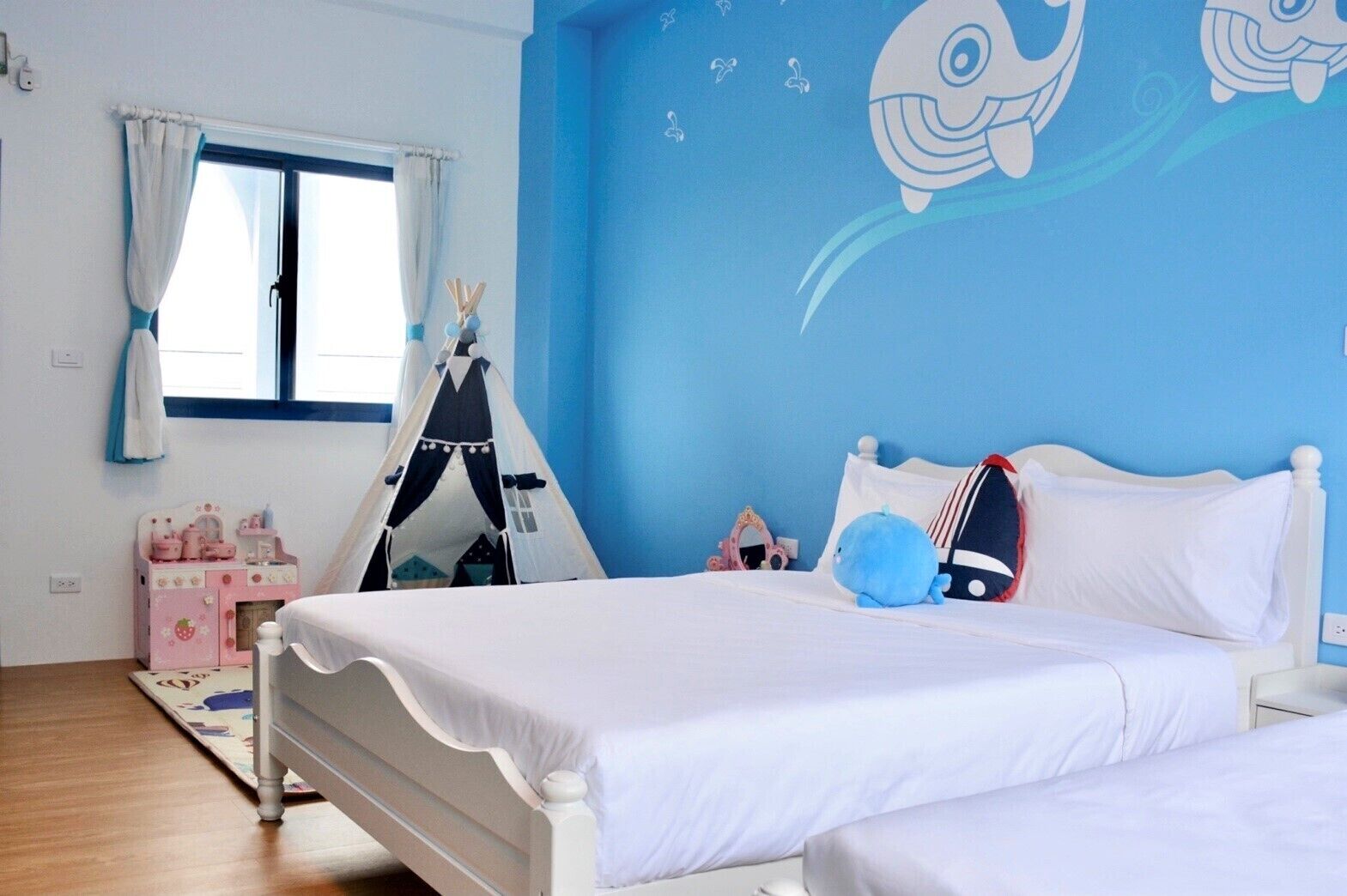 Un dormitorio con cama, una tienda de juegos y un mural en la pared.