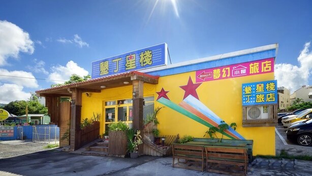 A brightly colored building with a sign indicating it is a hotel. - Kenting Star Inn (Hengchun)