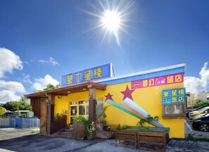 A brightly colored building with a sign indicating it is a hotel. - Kenting Star Inn (Hengchun)